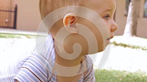 Close up video of baby boy tentatively crawling in grass