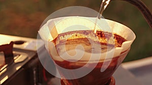 Close up video preparing pour over coffee outdoor in camping at sunrise