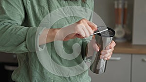 Close up video of woman grinding coffee with manual grinder in kitchen