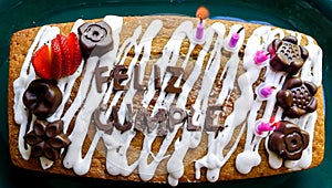 Close up view from above of a homemade happy birthday cake with words in spanish made of chocolate photo