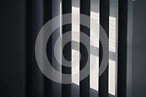 Close up view of an abstract black background with geometric vertical slats, backdrop with copy space, light and shadow