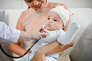 Close up view of adorable baby being checked by a doctor using a stethoscope. Childcare concept