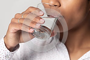 Close up view african female drinking still water quenches thirst