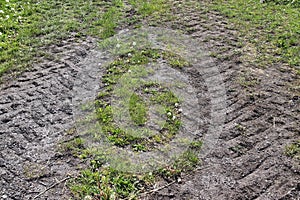 Close up view on agricultural fields with dry ground and tractor tracks