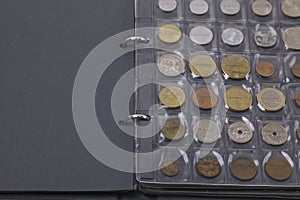 Close up view of album with collectible old coins from different countries. Numismatic concept.