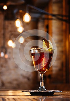 close-up view of alcoholic sazerac cocktail in glass on wooden table