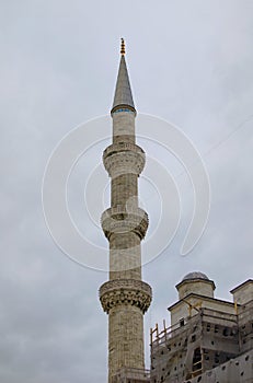 Close-up view of ancient minaret against cloudy sky. Minaret of the mosque of Hagia Sophia in Sultan Ahmed Park