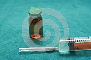 Close-up view of anesthetic drug and bottle on green cloth