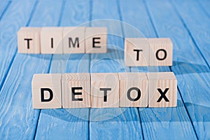 close up view of arranged wooden blocks into time to detox phrase on blue