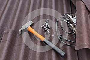 Close up view on asphalt roofing shingles background with hammer and nails