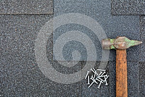 Close up view on Asphalt Roofing Shingles Background. Roof Shingles - Roofing. Asphalt Roofing Shingles Hammer and Nails