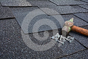Close up view on Asphalt Roofing Shingles Background. Roof Shingles - Roofing. Asphalt Roofing Shingles Hammer and Nails