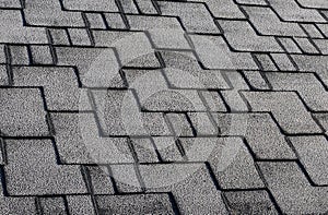 Close up view on Asphalt Roofing Shingles Background. Roof Shingles - Roofing. Roof shingles covered with frost