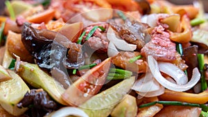 Close-up view of the background of sweet and sour stir-fry, consisting of pork pieces