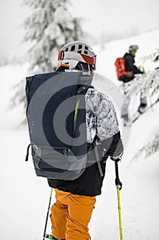 close-up view of backpack on back of male skier in ski equipment at skitour photo