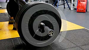 Close up view of barbell on floor in gym. Barbell falls to the floor after exercise. Barbell. Disassembled barbell on