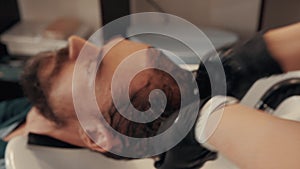 Close-up view of barber applying shampoo on man head