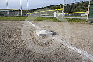 Close up view of a base on a clean baseball field on a bright, sunny day