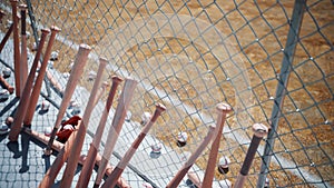 Close-up view of baseball equipment against a chain link fence