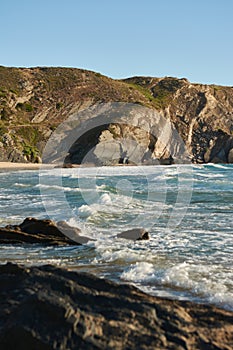 Close up view of the beach and rocks washed by the ocean waves. Atlantic Ocean, Portugal