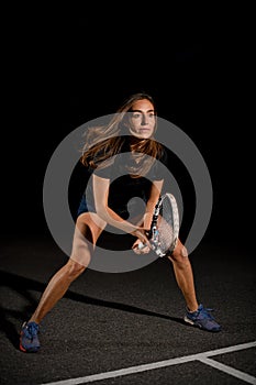 Close-up view on beautiful athletic woman with racket in special pose which preparing to hit tennis ball