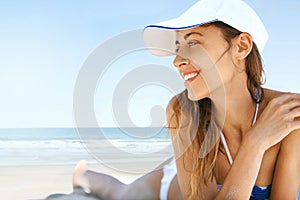 Close up view of beautiful athletic woman tanning in bikini on sandy beach at summer. Summer vacation concept.