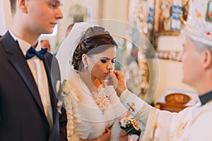 The close-up view of the beautiful bride kissing the wedding ring.