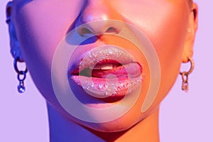 Close up view of beautiful woman lips in colourful bright light
