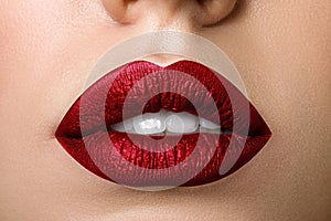 Close up view of beautiful woman lips with red matt lipstick photo