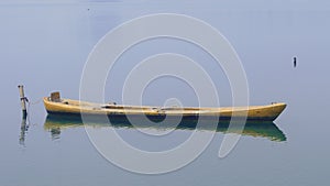 Close up view on beautiful wooden flat rowing boat moored on lake