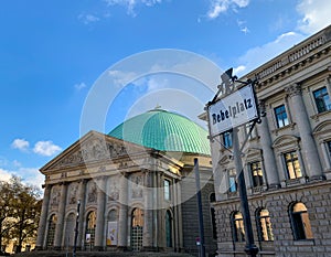 Close up view of Bebelplatz street sign with St. Hedwig`s Cathedral in background