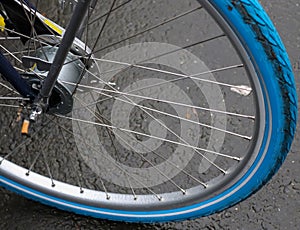 Close up view at a bicycle wheel with metal spokes