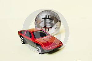 Close-up view of bitcoin and red car.