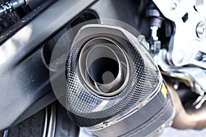 Close up view of a black carbon motorcycle exhaust pipe