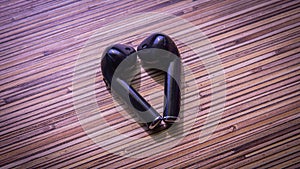 Close up view of black wireless bluetooth earphones or headphones on wooden table background
