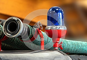 Close-up view of a blue light and fire hose on the roof of an antique fire engine