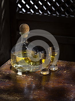 Tequila anejo and glasses on color background photo