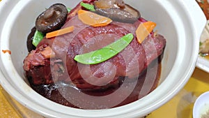 Close-up view of a bowl of delicious braised pork trotter with vegetables