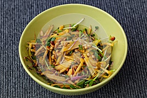 Close up view of bowl with healthy salad of popular sprouts , avocado, pine seeds, turnip. Healthy food concept