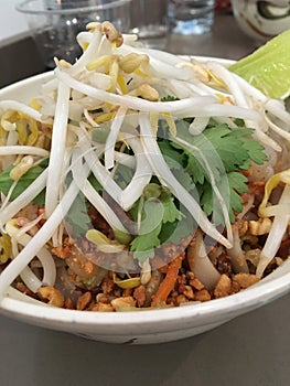 Close up view of a bowl of pad Thai dish in a real restaurant