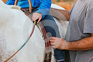 Close up view of a boy riding a horse in an assisted equine therapy session.