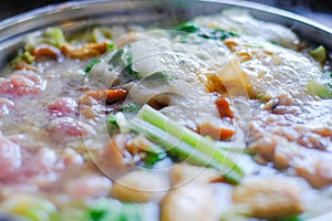 Close up view of bubble water in hot pot with meat vegetables. Shabu Shabu is style beef in hot pot dish of thinly sliced meat and