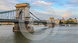 A close up view of the Budapest Chain bridge on the Danube river with Gresham Palace and sky in the background