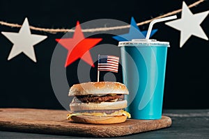 Close up view of burger with american flag and soda drink