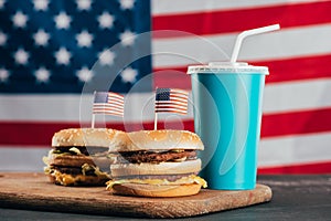 Close up view of burgers with american flags and soda drink
