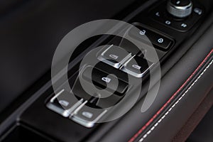 Close up view of button controlling window in modern car interior. Vehicle interior detail.