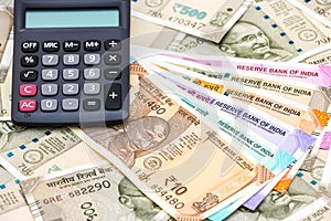 Calculator over brand new indian 10, 50, 100, 200, 500 and 2000 rupees banknotes. Colorful money background