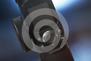 Close up view of a camera gimbal joystick control panel with buttons and screen display for video photography