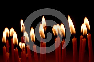 Close up view of the candles burning brightly in the dark.