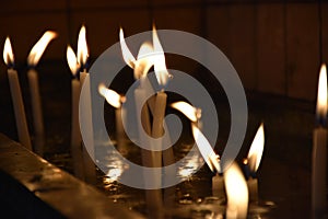 Close up view of the candles burning brightly in the dark